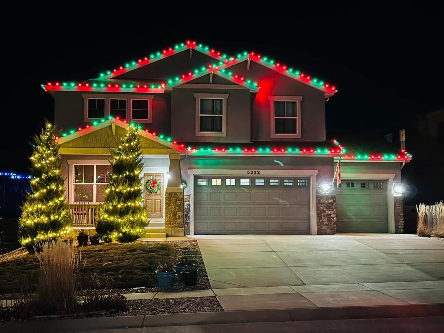 Red and green roofline holiday lighting display